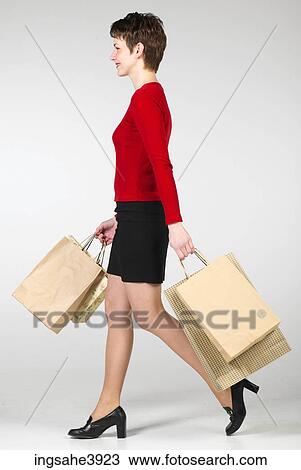 Young woman walking with several shopping bags View Large Photo Image Stock Image - Young woman walking with several shopping bags. Fotosearch
