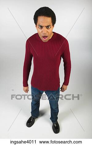 Stock Image - Angry man in jeans and red sweater. Fotosearch