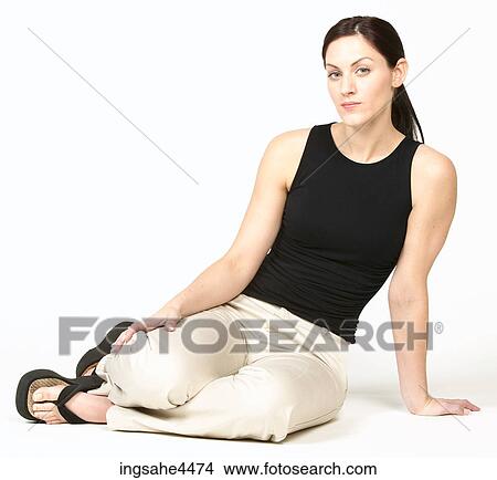 Picture - Angry woman in casual attire sitting on the ground. Fotosearch