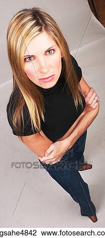 Angry young blond woman standing with her arms crossed in front of her View Large Photo Image Stock Image - Angry young blond woman standing with her arms crossed in front of her. Fotosearch