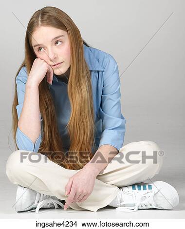 Picture - Bored teenaged girl sitting cross-legged . Fotosearch