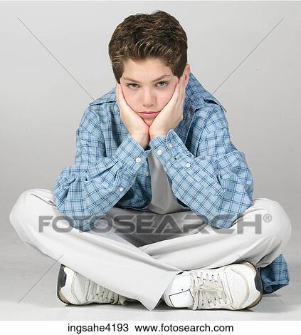 Stock Image - Bored teenager sitting cross-legged. Fotosearch