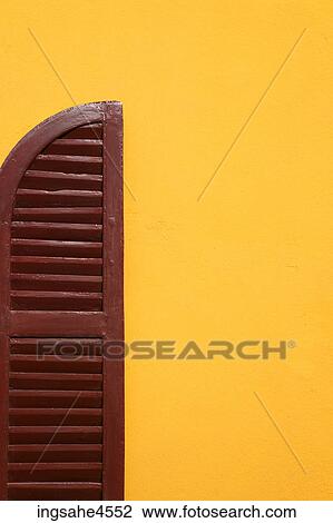 Brown wooden shutter in yellow wall View Large Photo Image Stock Image - Brown wooden shutter in yellow wall . Fotosearch