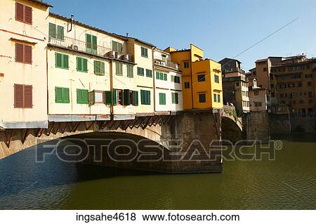 Stock Photo - Buildings on bridge stretching over river . Fotosearch