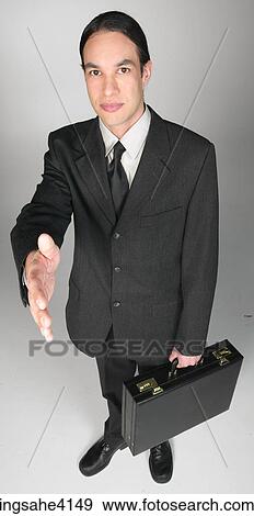 Stock Photo - Businessman holding briefcase and shaking hands. Fotosearch