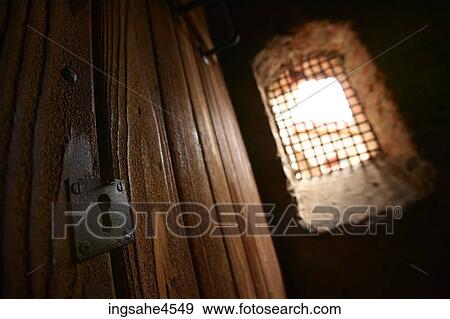 Close-up of lock on wooden door next to barred window View Large Photo Image Stock Photo - Close-up of lock on wooden door next to barred window . Fotosearch