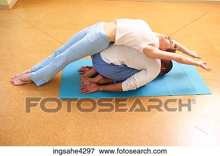 Couple in fish and child poses of partner yoga practice View Large Photo Image Stock Photo - Couple in fish and child poses of partner yoga practice . Fotosearch