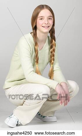 Crouching and smiling teenaged girl View Large Photo Image Stock Image - Crouching and smiling teenaged girl. Fotosearch