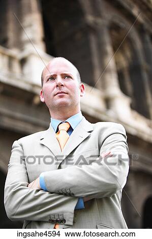 Frowning businessman in gray suit with crossed arms View Large Photo Image Picture - Frowning businessman in gray suit with crossed arms . Fotosearch