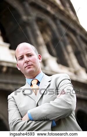Frowning businessman in gray suit with crossed arms View Large Photo Image Stock Image - Frowning businessman in gray suit with crossed arms . Fotosearch