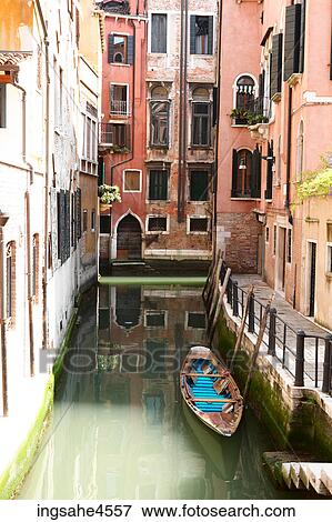 Gondola tied to pier in quiet Venetian canal View Large Photo Image Stock Photo - Gondola tied to pier in quiet Venetian canal . Fotosearch