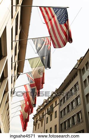 Stock Image - International flags hanging from top of building . Fotosearch