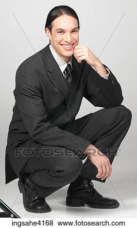 Kneeling and smiling businessman View Large Photo Image Stock Photo - Kneeling and smiling businessman. Fotosearch