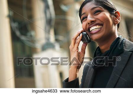 Stock Image - Laughing woman on cell phone. Fotosearch