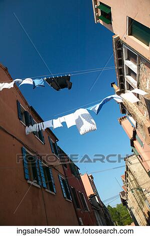 Lines of laundry from brick houses blowing in the breeze View Large Photo Image Stock Image - Lines of laundry from brick houses blowing in the breeze . Fotosearch
