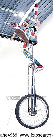 man juggling on unicycle View Large Photo Image Stock Photo - man juggling on unicycle . Fotosearch