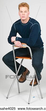 Man sitting on a high chair View Large Photo Image Stock Photography - Man sitting on a high chair . Fotosearch