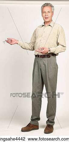 Stock Image - Man talking and gesturing with his eyeglasses. Fotosearch