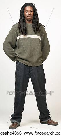 Stock Image - Man with dreadlocks wearing jeans and sweater . Fotosearch