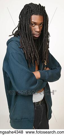 Stock Photo - Pouting man with dreadlocks in jeans and sweatshirt. Fotosearch