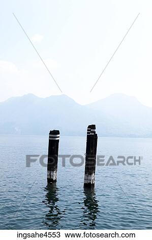 Rotting dock posts in misty mountain-lined lake View Large Photo Image Stock Image - Rotting dock posts in misty mountain-lined lake . Fotosearch