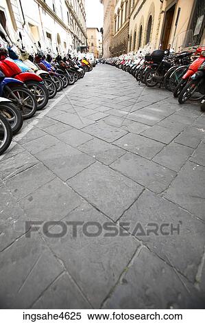 Rows of scooters parked along street View Large Photo Image Stock Photography - Rows of scooters parked along street . Fotosearch