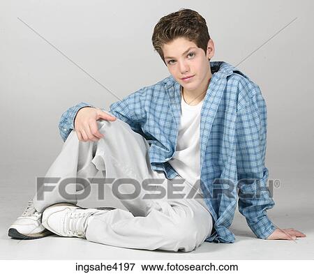 Stock Photo - Seated teenaged boy in blue shirt . Fotosearch