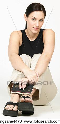 Seated young woman in casual attire holding book View Large Photo Image Stock Image - Seated young woman in casual attire holding book . Fotosearch