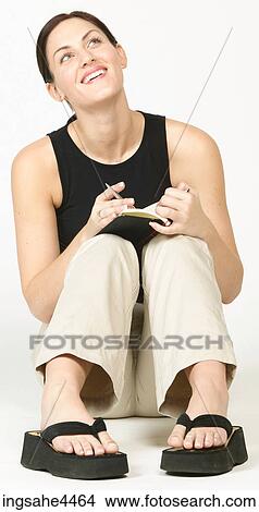 Seated young woman laughing and writing in book View Large Photo Image Picture - Seated young woman laughing and writing in book. Fotosearch