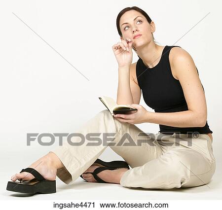 Seated young woman thinking and writing in book View Large Photo Image Stock Image - Seated young woman thinking and writing in book . Fotosearch