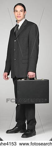 Serious businessman carrying briefcase View Large Photo Image Stock Image - Serious businessman carrying briefcase. Fotosearch
