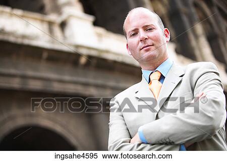 Serious businessman in gray suit with crossed arms View Large Photo Image Stock Photography - Serious businessman in gray suit with crossed arms . Fotosearch