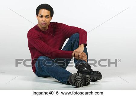 Serious man relaxing in jeans and sweater View Large Photo Image Stock Photograph - Serious man relaxing in jeans and sweater. Fotosearch