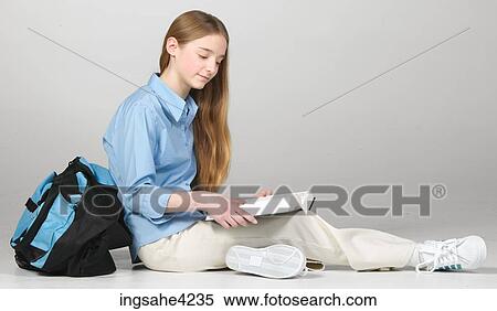 Serious teenaged girl reading from textbook View Large Photo Image Stock Photography - Serious teenaged girl reading from textbook. Fotosearch