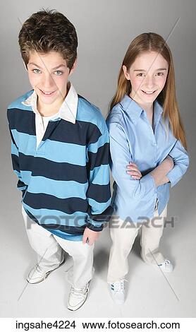 Smiling boy and girl standing beside each other View Large Photo Image Picture - Smiling boy and girl standing beside each other . Fotosearch