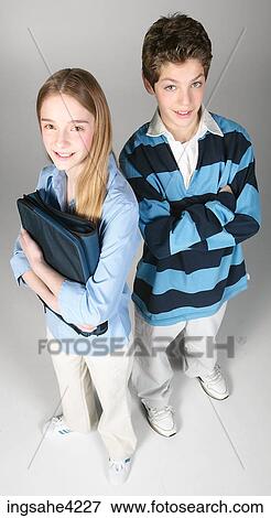 Smiling boy and girl standing holding school book View Large Photo Image Stock Photo - Smiling boy and girl standing holding school book. Fotosearch