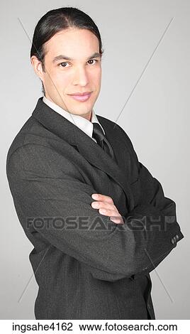 Stock Image - Smiling businessman with crossed arms . Fotosearch