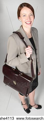 Stock Image - Smiling businesswoman carrying briefcase . Fotosearch