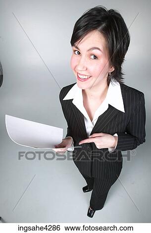Stock Photograph - Smiling businesswoman in black suit pointing to document. Fotosearch