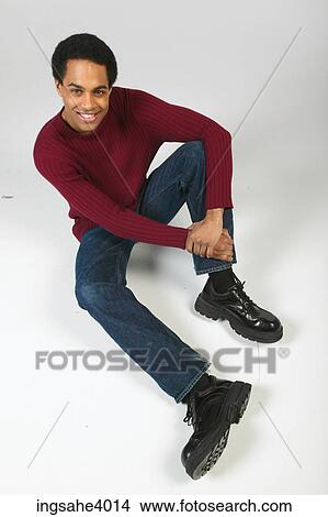 Smiling man relaxing in jeans and sweater View Large Photo Image Picture - Smiling man relaxing in jeans and sweater. Fotosearch