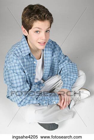 Smiling teenaged boy sitting cross-legged View Large Photo Image Stock Photography - Smiling teenaged boy sitting cross-legged. Fotosearch