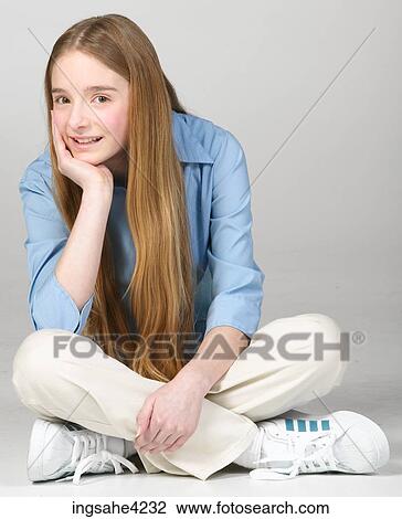 Smiling teenaged girl sitting cross-legged View Large Photo Image Stock Image - Smiling teenaged girl sitting cross-legged. Fotosearch