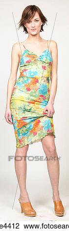 Stock Image - Smiling woman in colorful sundress. Fotosearch