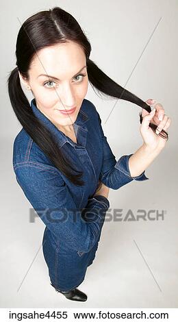Smiling woman pulling on her pigtail View Large Photo Image Stock Photography - Smiling woman pulling on her pigtail. Fotosearch