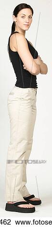 Stock Image - Standing young woman in casual attire. Fotosearch