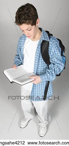 Teenaged boy carrying book bag and reading book View Large Photo Image Stock Image - Teenaged boy carrying book bag and reading book. Fotosearch