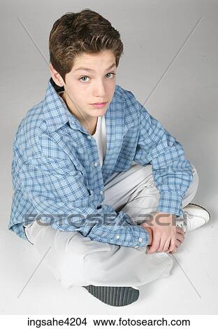 Picture - Teenaged boy sitting cross-legged. Fotosearch