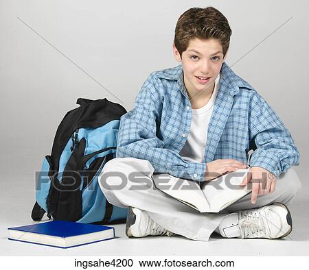 Teenaged boy studying from textbook View Large Photo Image Stock Image - Teenaged boy studying from textbook. Fotosearch