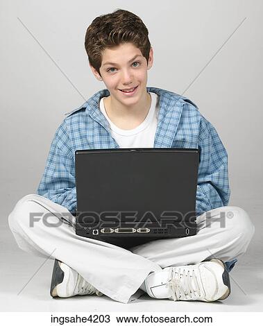 Stock Image - Teenaged boy using laptop computer . Fotosearch