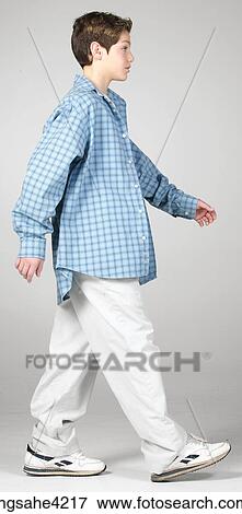 Stock Photo - Walking teenaged boy in blue shirt. Fotosearch